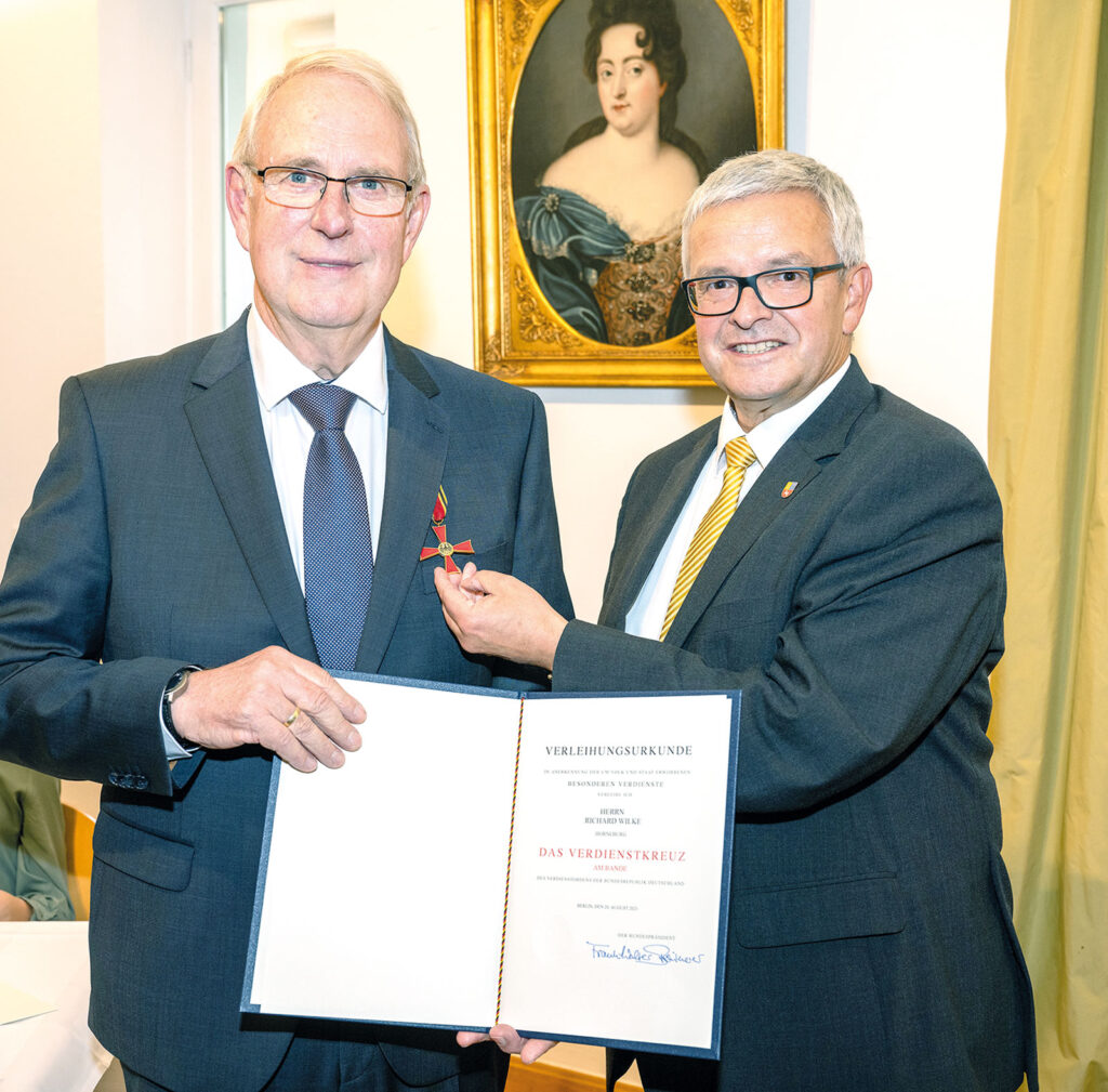 Landrat Michael Roesberg (r.) überreicht Richard Wilke im Namen des Bundespräsidenten das Bundesverdienstkreuz im Schloss Agathenburg. Foto: Landkreis Stade/ Martin Elsen